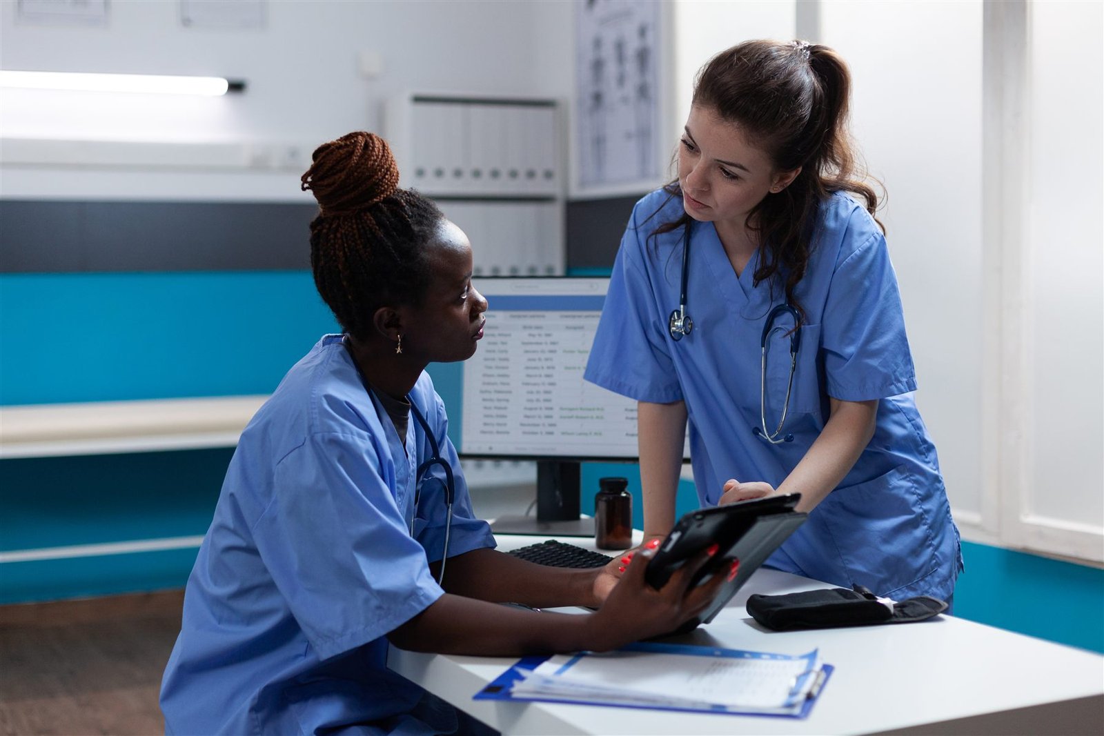 Two of our nurses reviewing care records together on a tablet