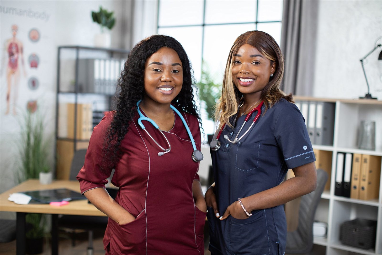 Two smiling Phoebe Grove care professionals in uniform, side by side