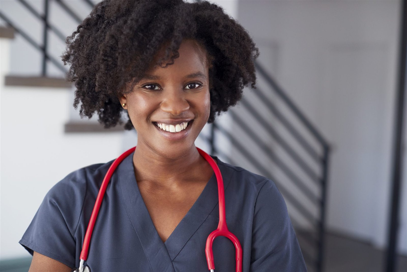A smiling nurse in uniform with a stethoscope — one of our vetted care professionals